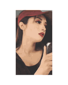 a woman wearing a red hat is taking a selfie
