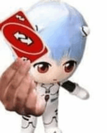 a person is holding a red card with an arrow on it in front of a doll .