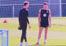 two soccer players are standing on a field talking
