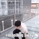 a man is standing on a glass walkway with the words i 'm rolling away above him