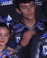 a man and a girl in cheerleading uniforms are dancing together .