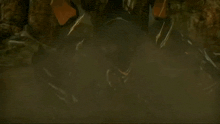 a black robot with red eyes is standing in front of a rocky mountain