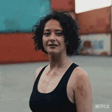 a woman in a black tank top with netflix written on the bottom right