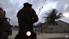 a man in a black uniform stands in front of a fence with the words virtual rio written on it
