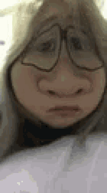 a close up of a woman wearing glasses and making a funny face .
