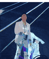 a man in a white suit is singing into a microphone on stage