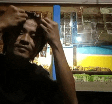 a man adjusts his hair in front of a sign that says ' aa ' on it