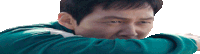 a man wearing a green jacket is covering his mouth with his arm .
