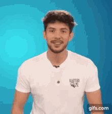 a man with a beard is wearing a white t-shirt with kaotiko on it .