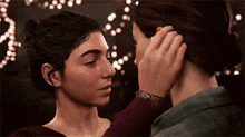 a couple of women are standing next to each other and touching their faces .
