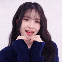 a woman wearing a blue sweater is making a face