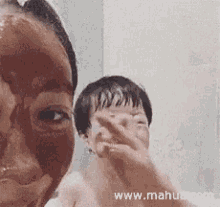 a woman and a child are taking a selfie with a mask on their face .