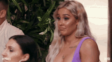 a woman in a purple tank top is looking at something