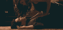 a man and a woman are laying on a bed and the woman is touching the man 's neck