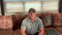 a man is sitting on a couch wearing a hat that says ' u.s. army ' on it