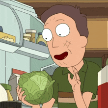 a man in a green shirt is holding a cabbage in front of a refrigerator