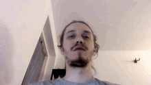 a man with long hair and a beard is taking a selfie