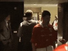 a man in a red shirt that says ' slazenger ' on the front
