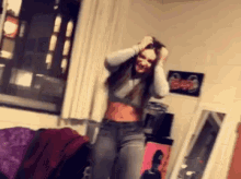 a woman is dancing in a room with a picture on the wall that says ' bar '