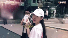 a woman wearing a white hat is standing next to a man holding a piece of paper with momo written on it
