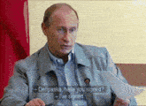 a man sitting in front of a microphone with the words deripaska have you signed on the screen