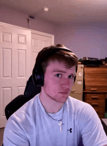 a young man wearing headphones and a cross necklace