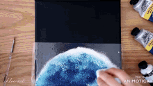 a person is cleaning a painting with a cloth that says made in animatica