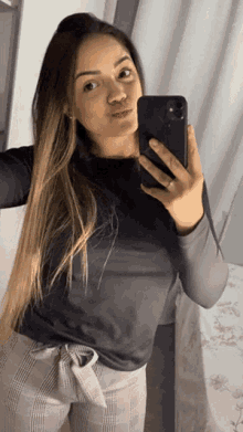 a woman is taking a selfie in front of a mirror with her phone