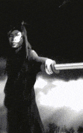a woman with long hair is holding a sword in a black and white photo