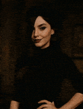 a woman wearing a black beret and a black turtleneck is smiling .