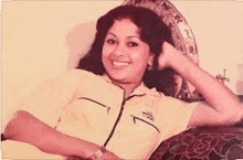 a woman is sitting on a couch with her hand in her hair .