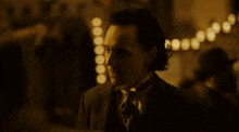 a man in a suit and tie is standing in a dark room