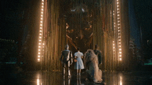 a group of people are standing in front of a statue