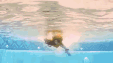 a person is swimming in a pool with a gummy bear in their hand .