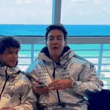 a man wearing a silver jacket that says ubs on it