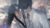 a woman with a flower in her hair kisses a man under an umbrella