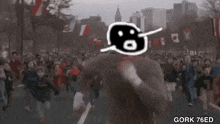 a man is running in front of a crowd of people in a crowded street .