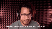 a man wearing glasses and headphones is saying what can i say ? i 'm a giggly bitch