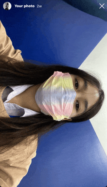 a woman wearing a tie dye face mask with the words your photo 2w below her
