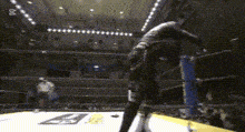 a person is standing in a boxing ring with the letter b on the floor