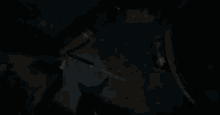 a silhouette of a person standing in a dark room with snow falling from the ceiling .