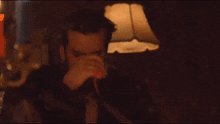 a man with a beard is sitting in front of a lamp with his eyes closed