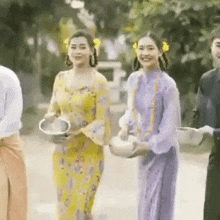 a group of people in traditional clothes are walking down a street .