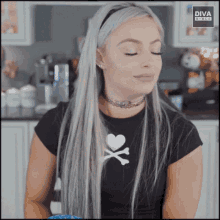 a woman wearing a black shirt with a heart and crossbones on the front