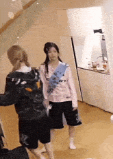 two women are standing next to each other in a room .