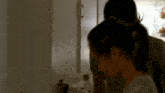 a man and woman are standing in a kitchen looking at something