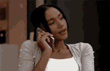 a woman is talking on a cell phone in a room .
