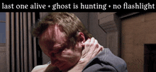 a man is being held by a woman with the words last one alive ghost is hunting no flashlight below him