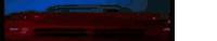 a close up of a red car 's headlights in a dark room .