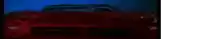 a close up of a red car 's headlights in a dark room .